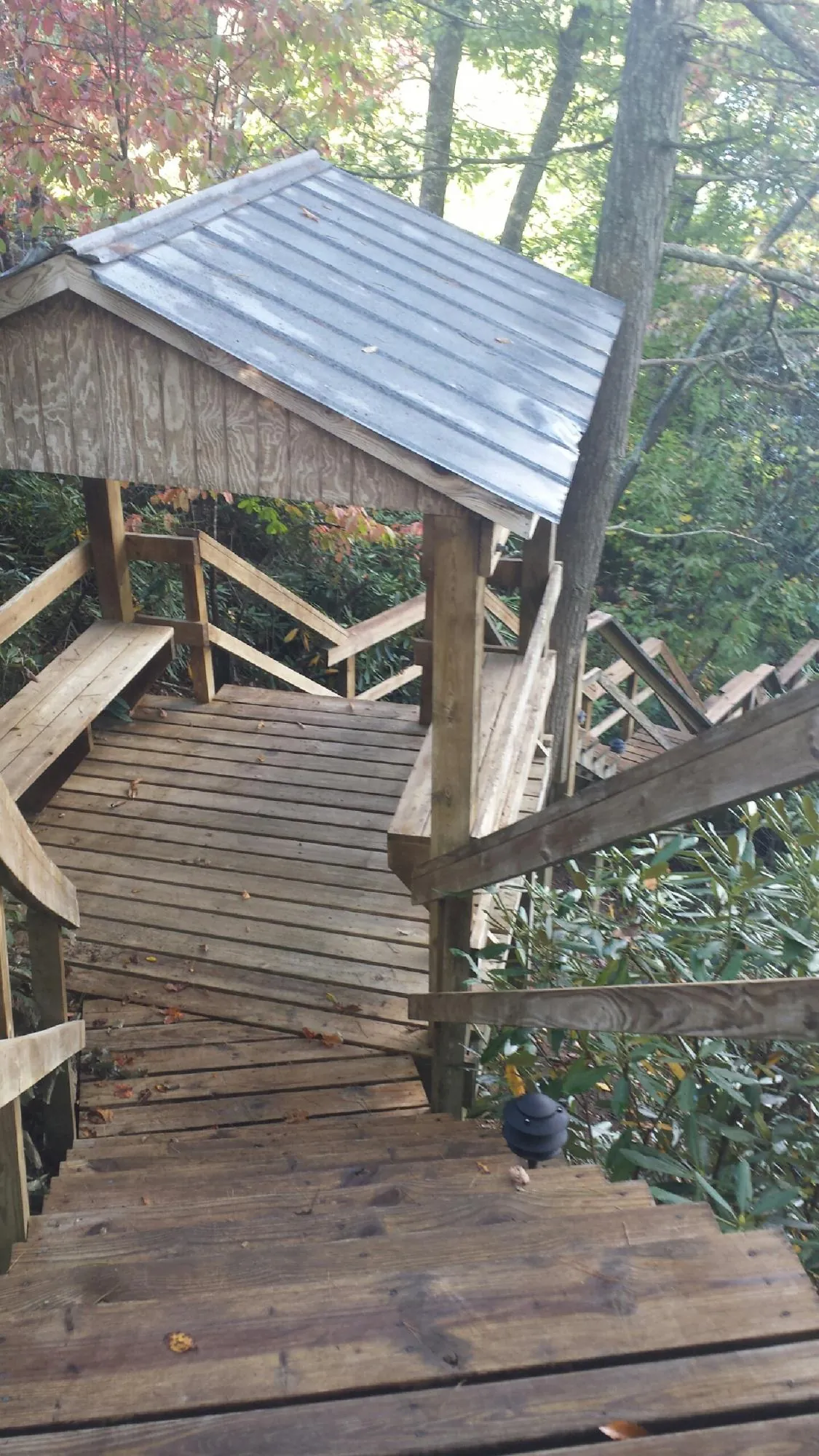 Metal roofed shelter over wooden steps on a wooded walkway — Skylight Repair & Installation work by our crew in Soap Lake
